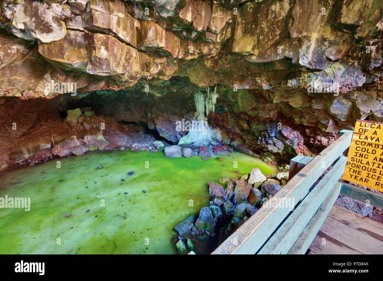 Tourist at frozen pool inside Ice Caves in summer, inside lava field at
