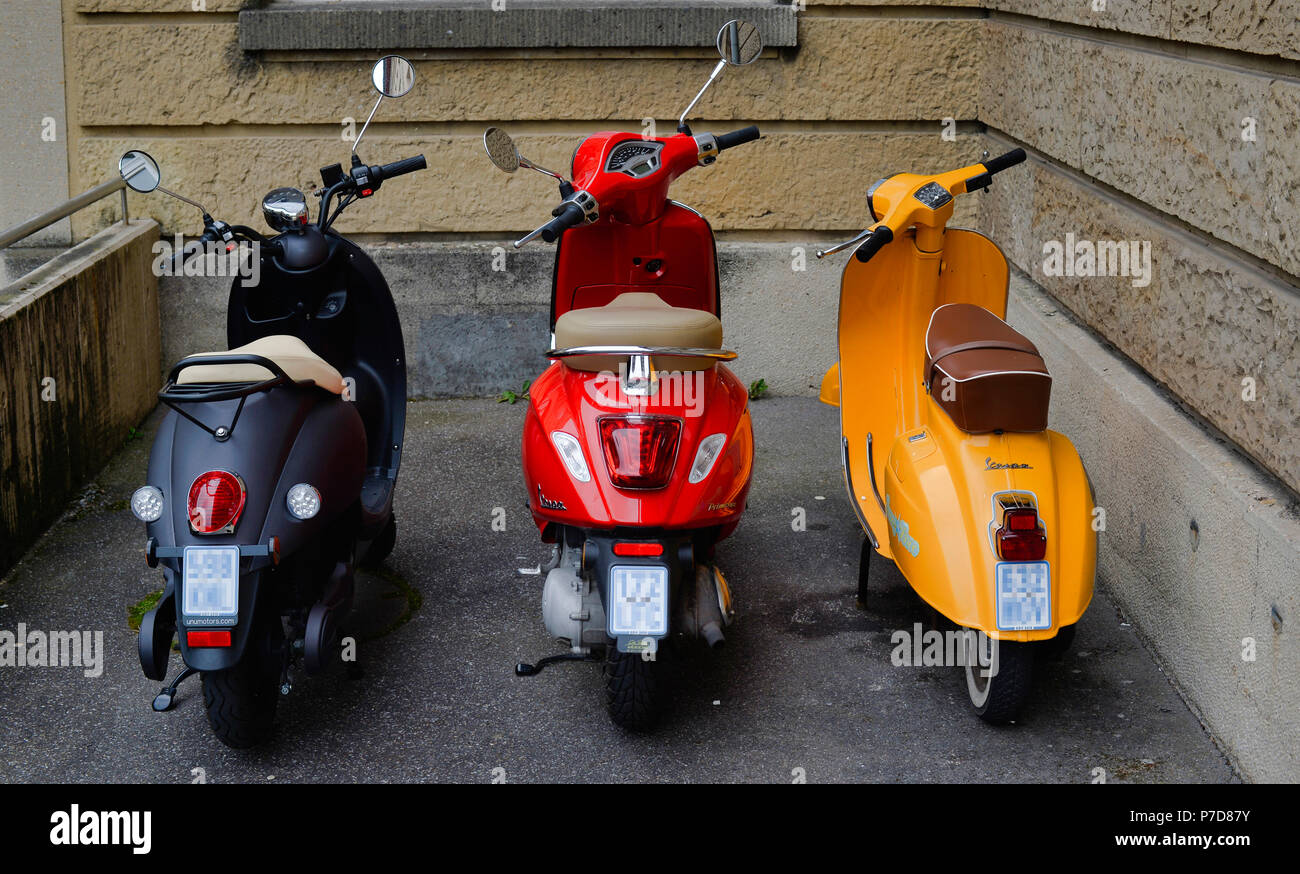 Three scooters in German national colours black-red-gold in a courtyard, Stuttgart, Baden-Württemberg, Germany Stock Photo