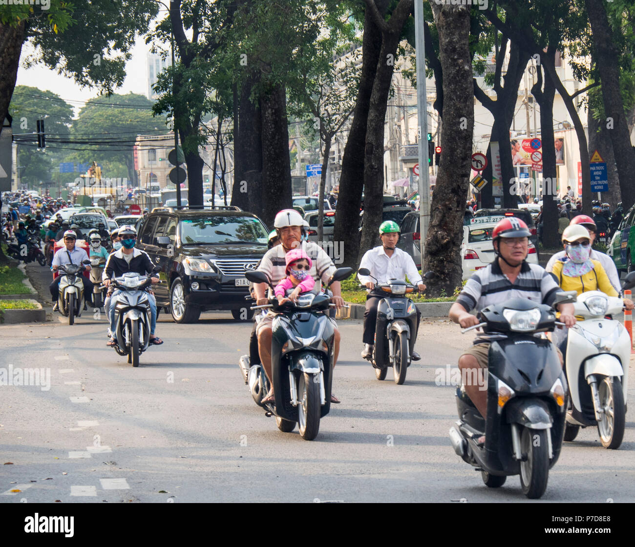 A young girl riding as a passenger on a motorcycle in traffic Ho Chi Minh City Vietnam. Stock Photo