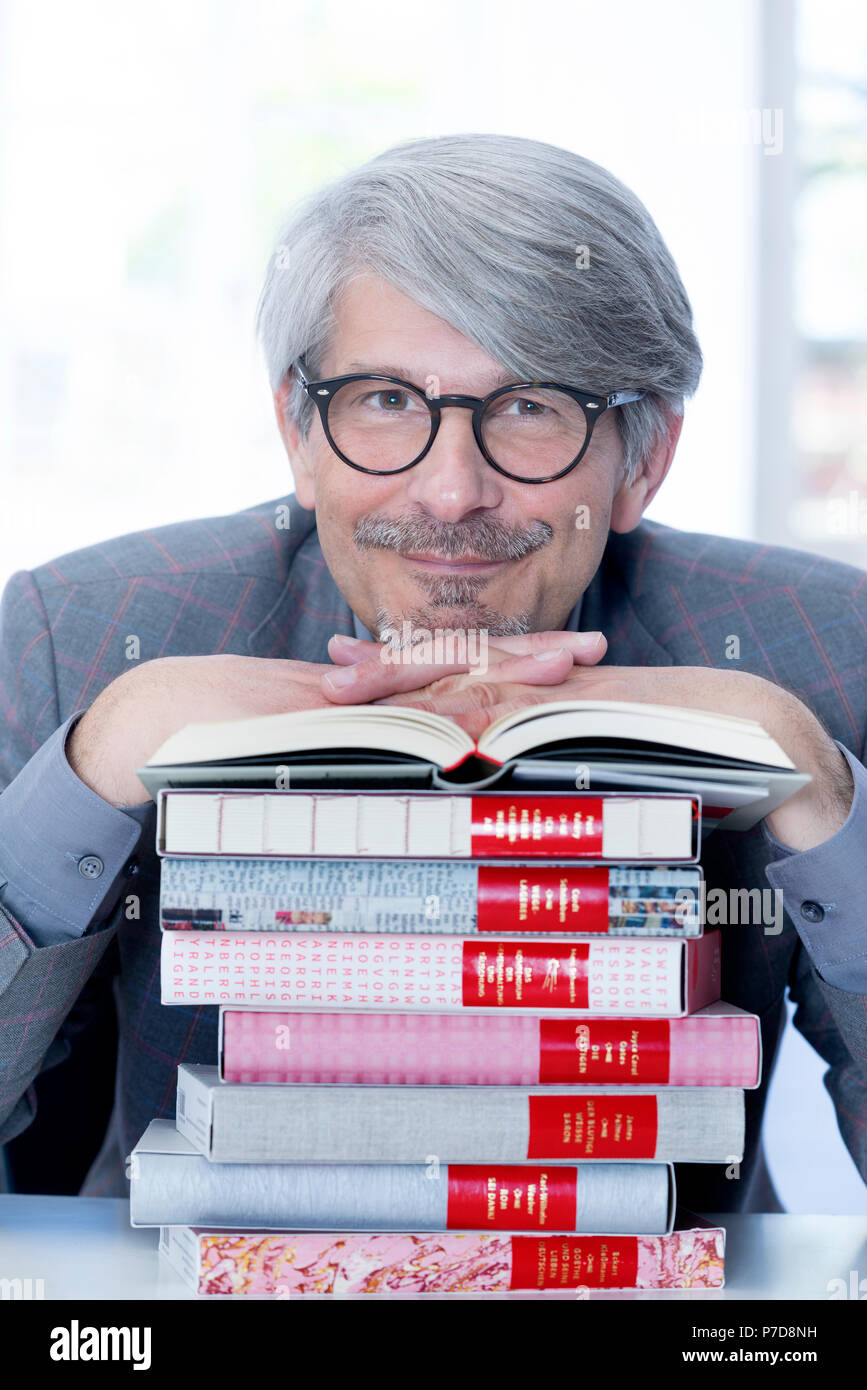 Man leaning on a book pile Stock Photo Alamy