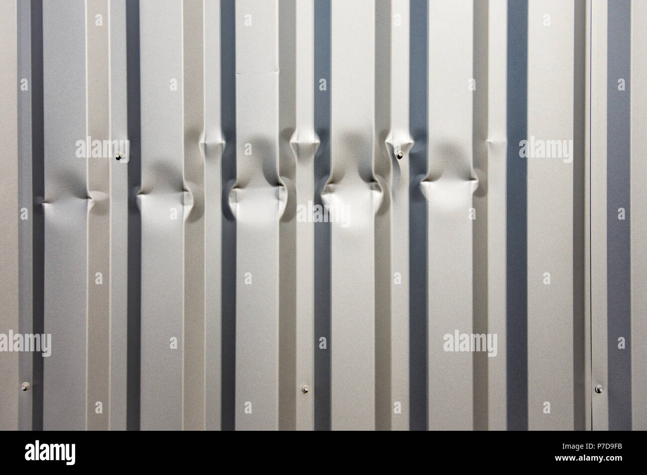 Damaged aluminium cladding on building wall - France. Stock Photo