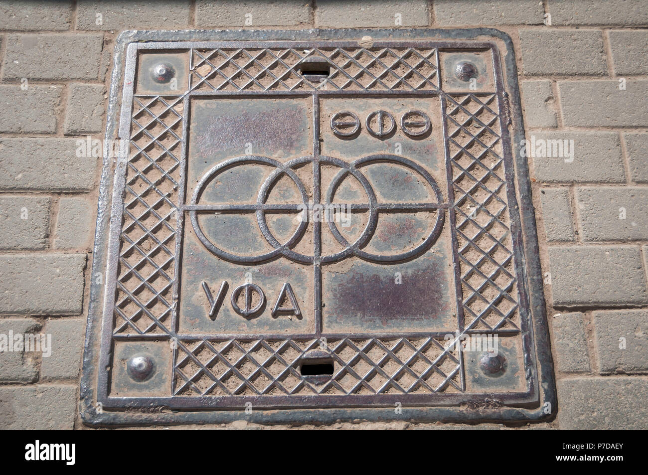 Stylized manhole cover stock image. It says 'Ufa' in the Bashkir Turkish language on the top, and in Russian on the bottom. Ufa, Russia, May 2016. Stock Photo