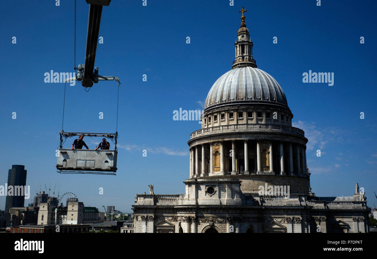 Window cleaners are suspended in a cradle above an office block next to St Paul's Cathedral, in Central London, Britain July 3, 2018. Stock Photo