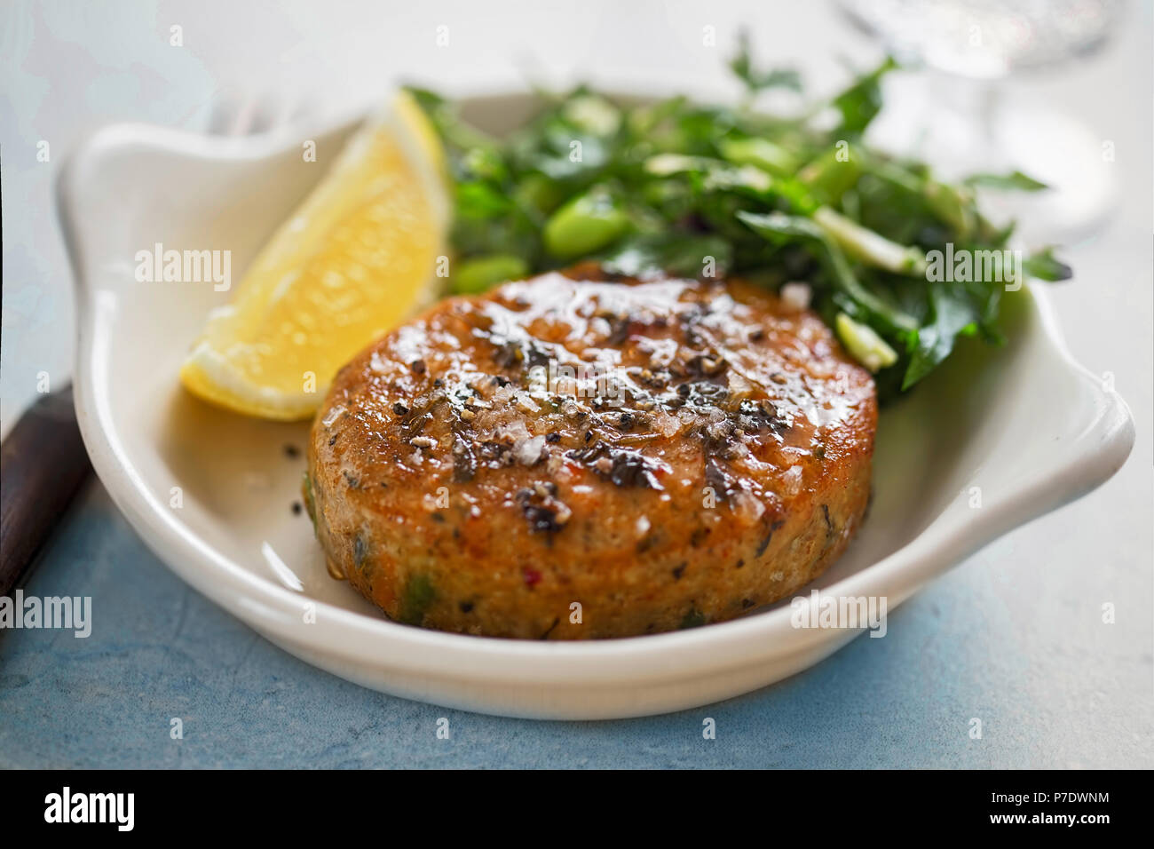 Thai style fish cakes with spicy soy glaze, green salad and lemon wedge