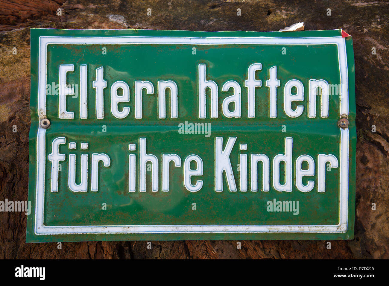 German warning sign at a construction site 'Eltern haften fuer ihre Kinder' translates into 'Parents are liable for their children' in English languag Stock Photo