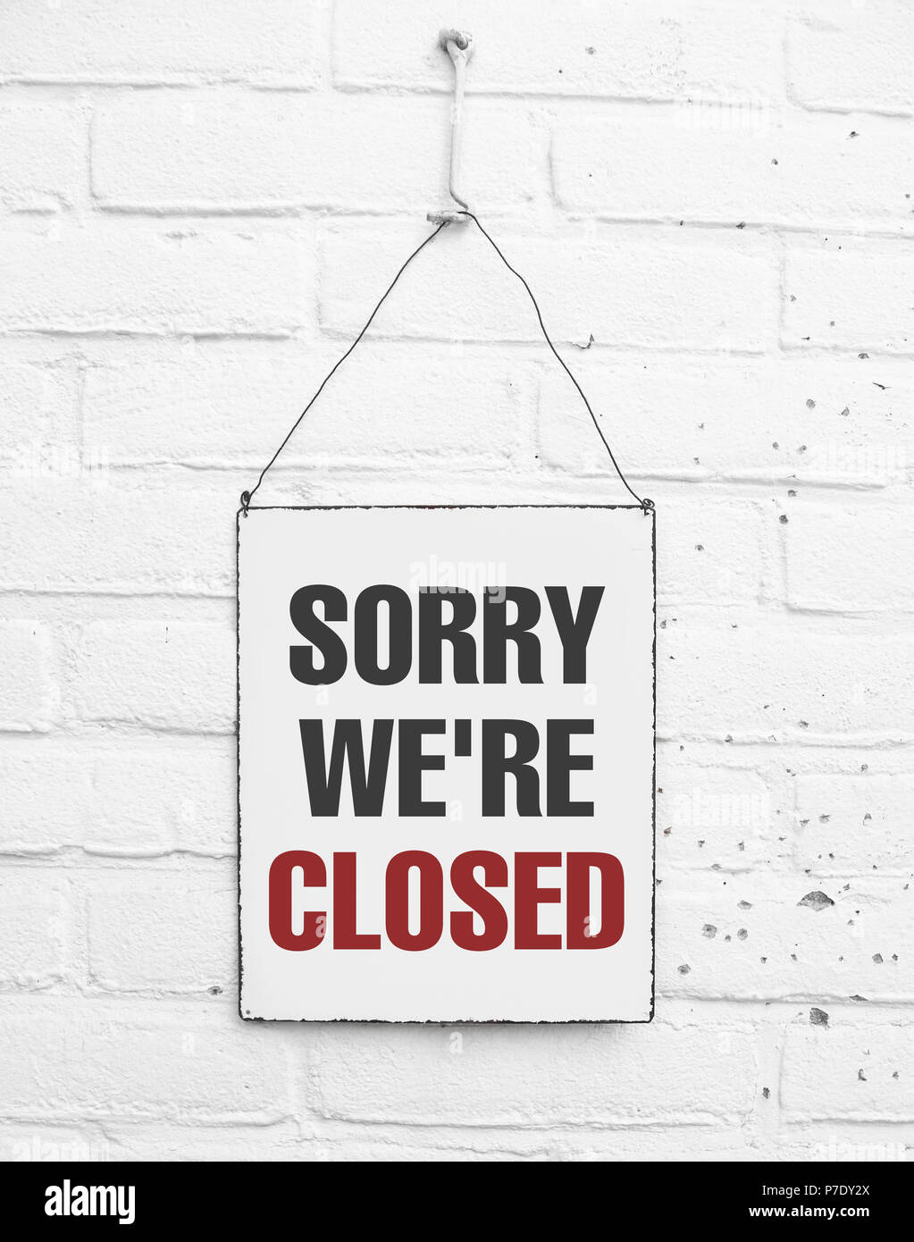 Sorry we're closed sign metal plate banner on white brick background Stock Photo