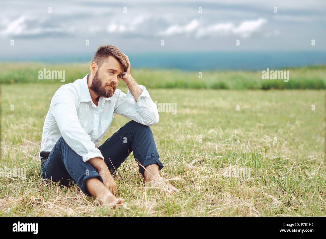 человек сидит на поляне. человек сидит на поляне. человек сидит на поляне. человек около дерева. парни на природе.