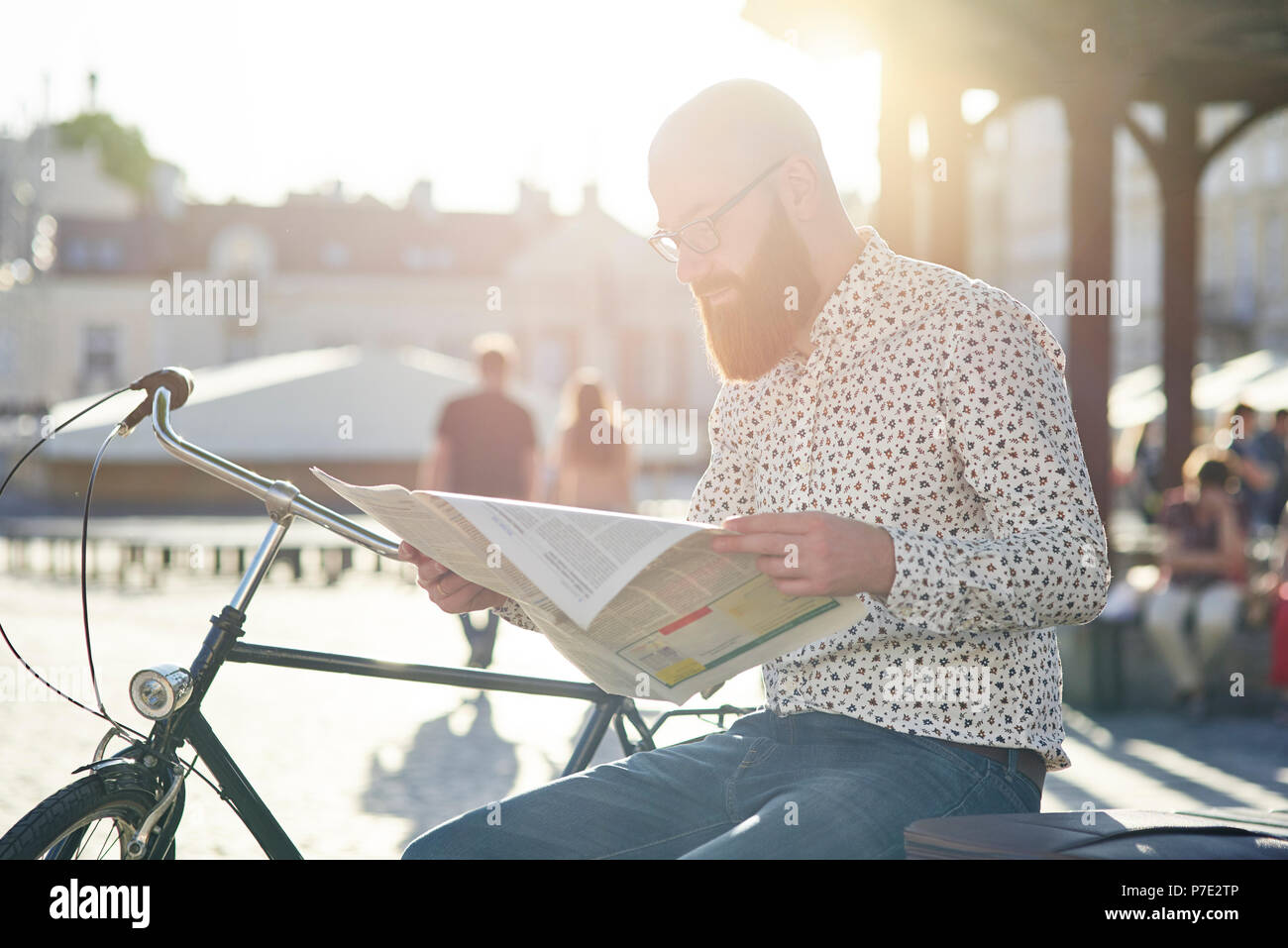Bearded man reading newspaper in street Stock Photo - Alamy