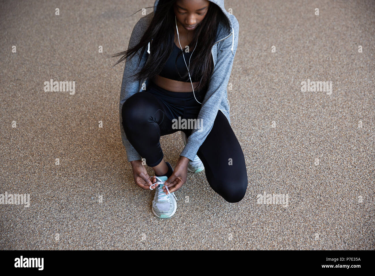 Young woman tying shoelace Stock Photo