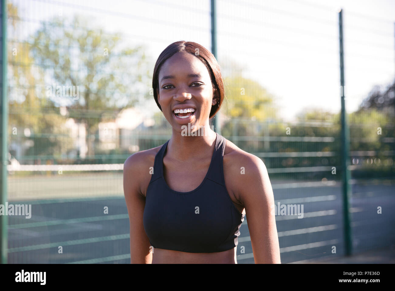 Young woman smiling in sports court Stock Photo