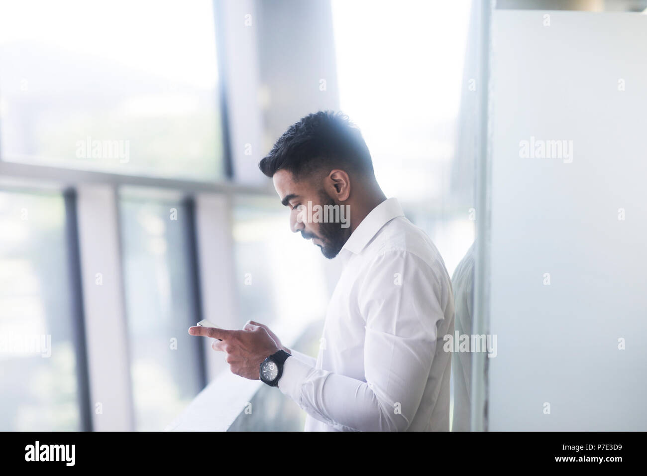 Young man using mobile phone in office Stock Photo