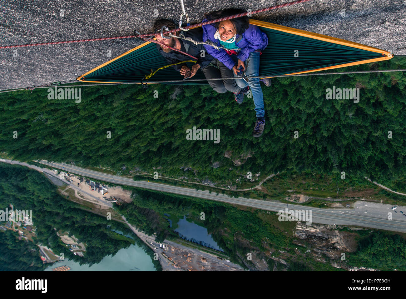 Man and woman sitting on hammock on bellygood ledge, The Chief, Squamish, Canada, overhead portrait Stock Photo