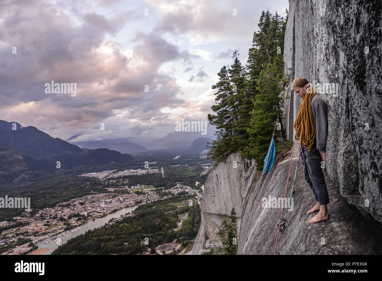 Young male climber standing barefoot on bellygood ledge, The Chief, Squamish, Canada Stock Photo