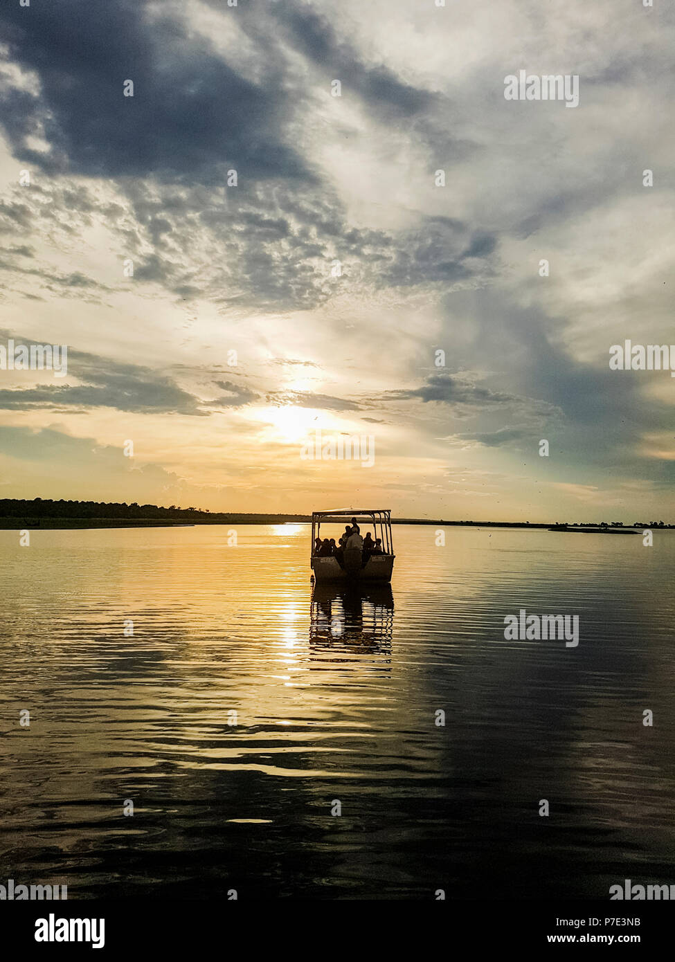 Silhouette of boat on river at sunset, Chobe National Park, Botswana Stock Photo