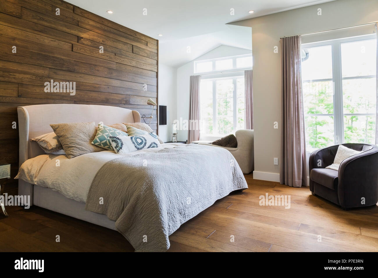 King size bed in bedroom with hickory wood floorboards Stock Photo Alamy