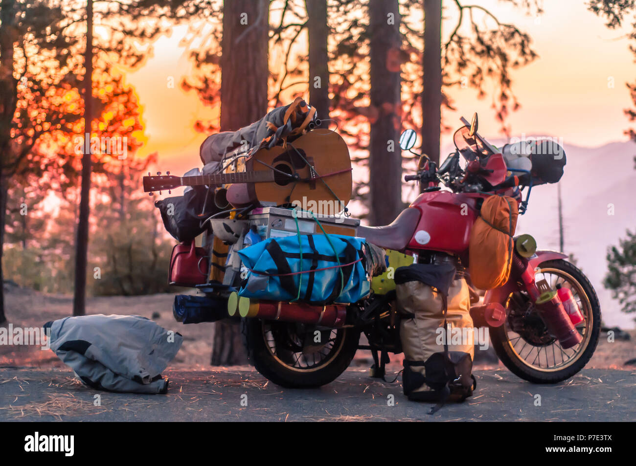 Part unloaded touring motorcycle parked on forest roadside at sunset, Yosemite National Park, California, USA Stock Photo