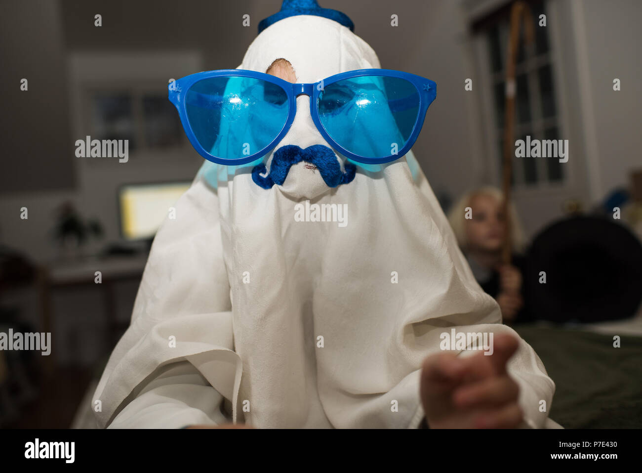 Girl dressed up as ghost with mustache and over sized sunglasses Stock Photo