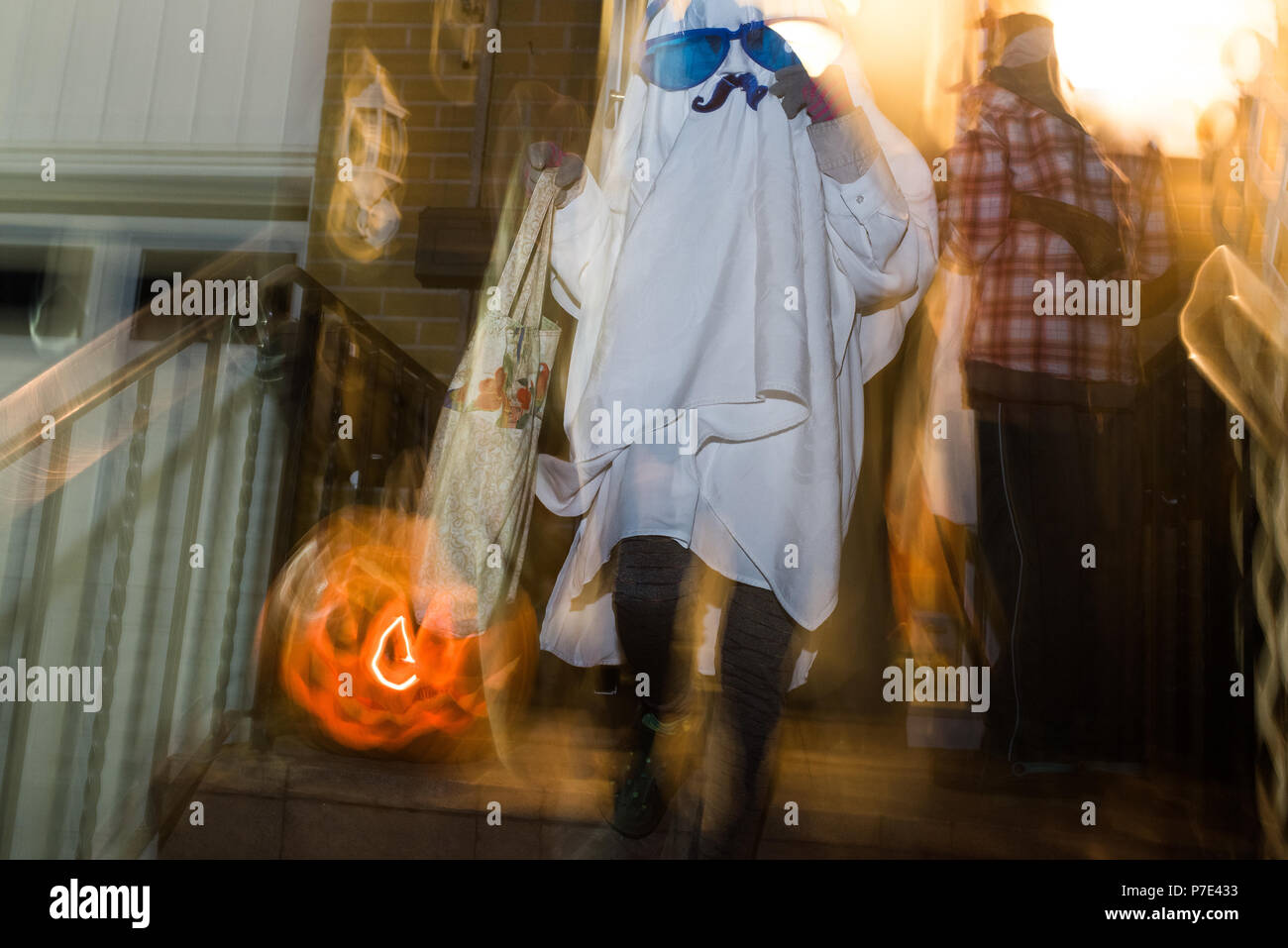 Girl dressed as ghost with mustache and over sized sunglasses, blurred Stock Photo