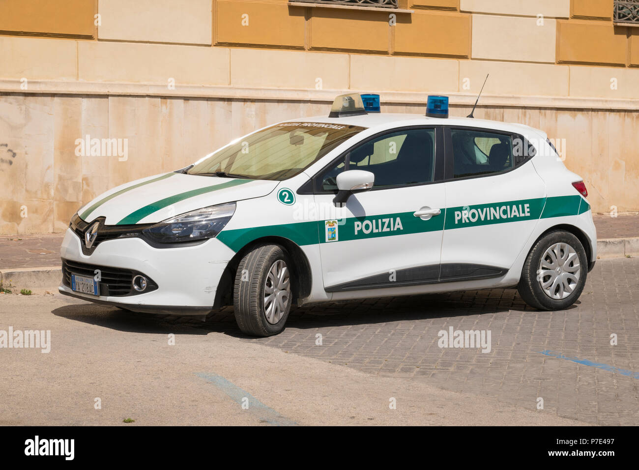 Italy Sicily Agrigento modern police car white green stripe Polizia Provinciale Renault Clio blue lights parked cobble cobbled street road Stock Photo