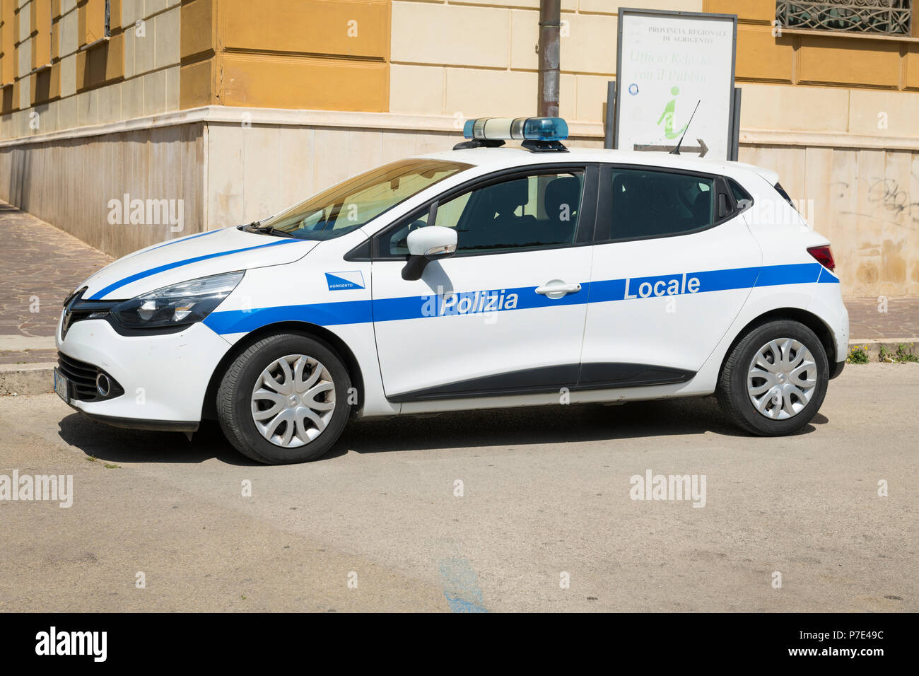 Italy Sicily Agrigento modern police car white blue stripe Polizia Locale Renault Clio blue lights parked cobble cobbled street road Stock Photo