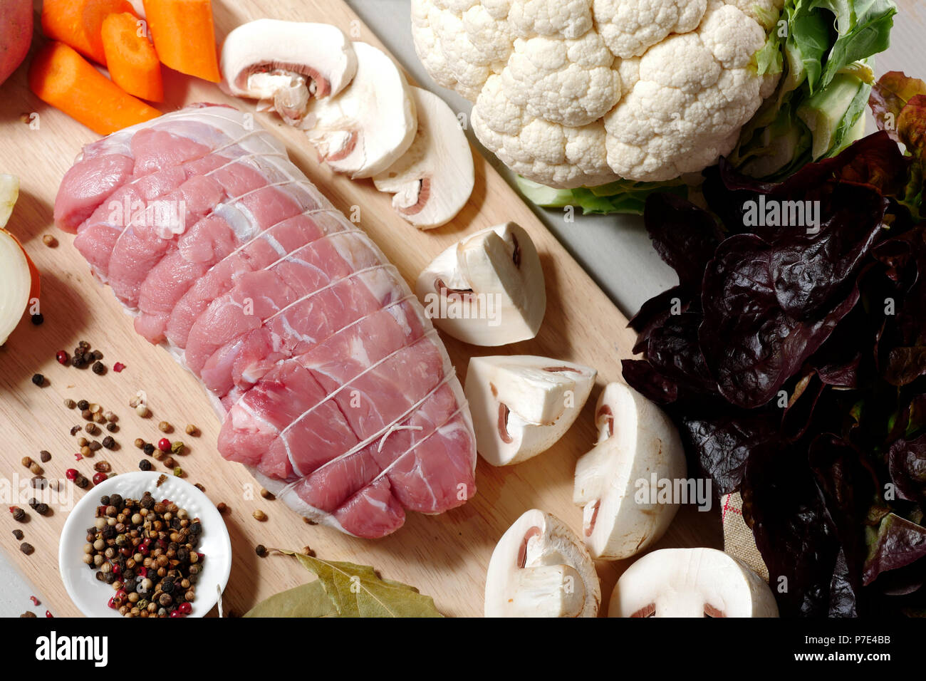 preparation of uncooked roast pork with mushrooms Stock Photo Alamy