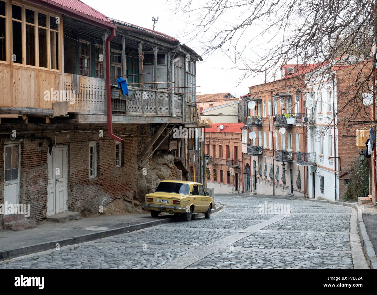 Old car parked along a cobblestone street in Tbilisi old town district, Georgia Stock Photo