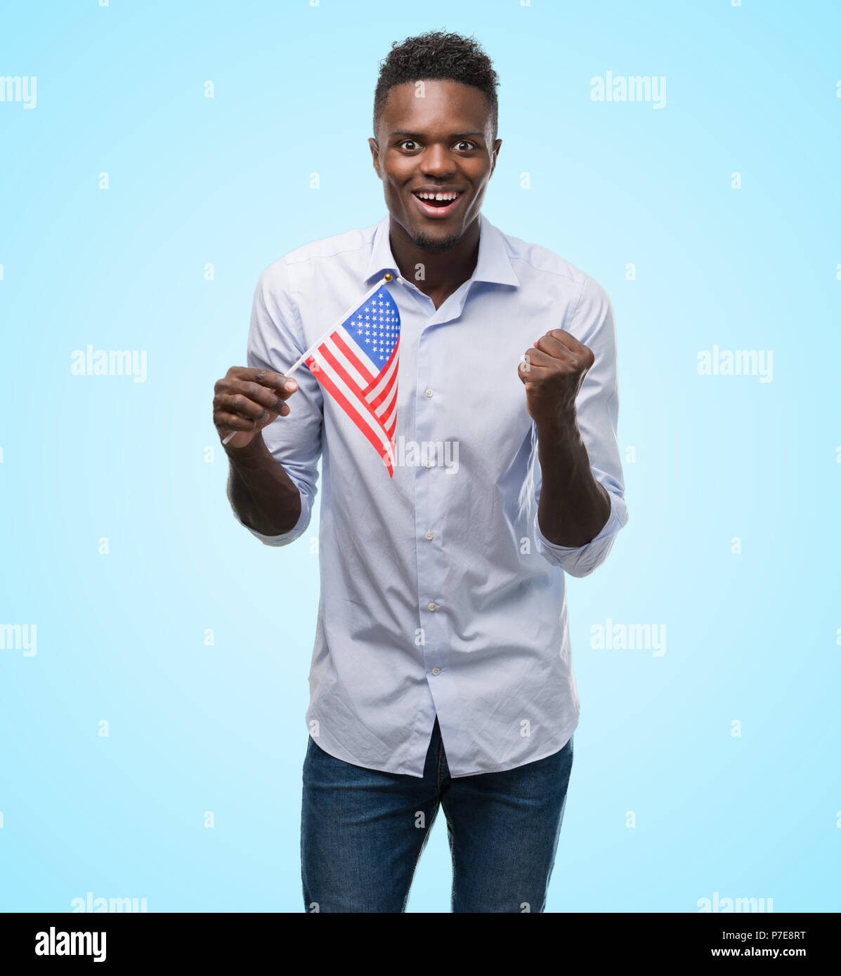 Young african american man holding USA flag screaming proud and ...
