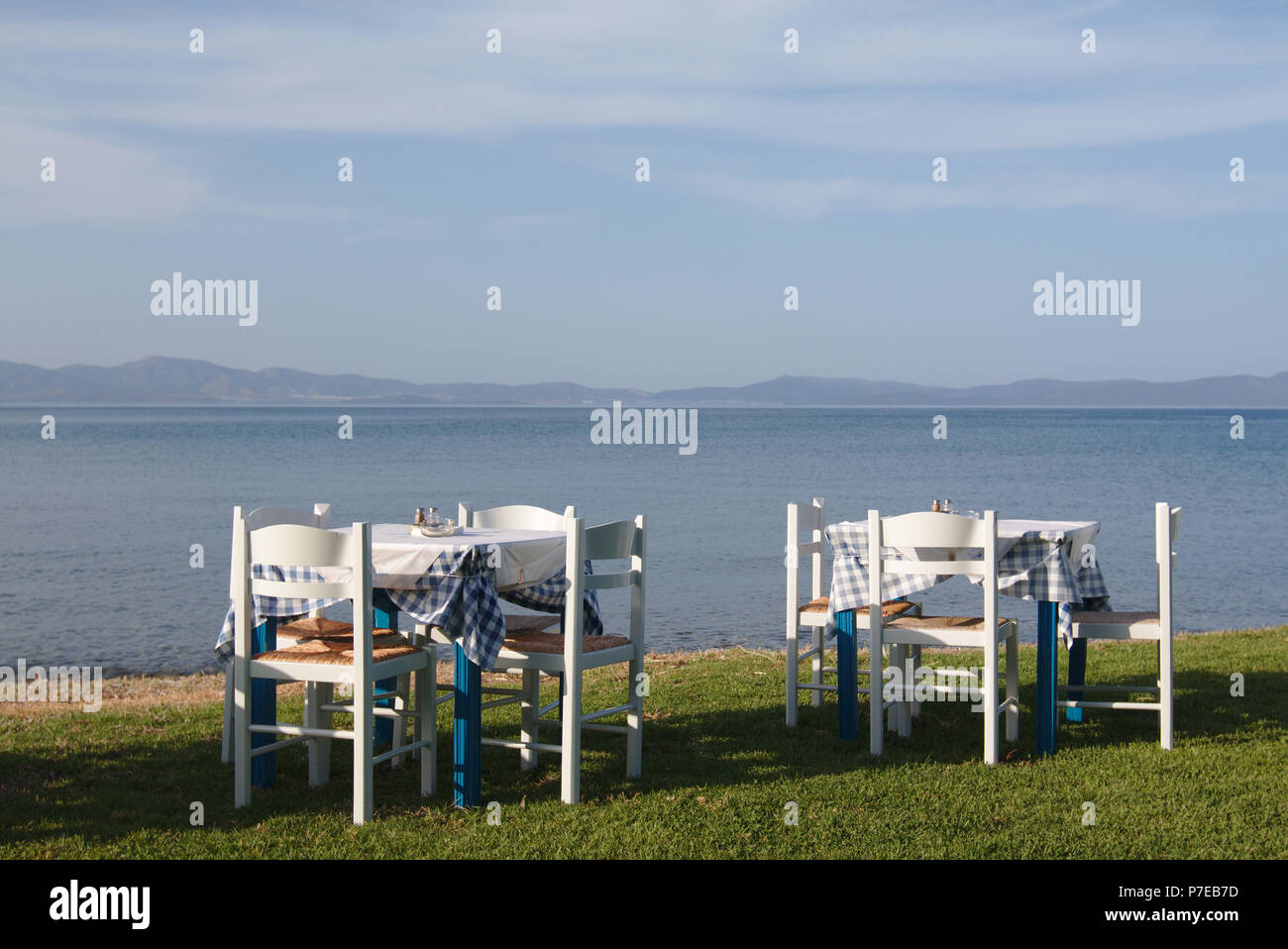 Restaurant tables set at the beach, overlooking Turkish shore Stock Photo