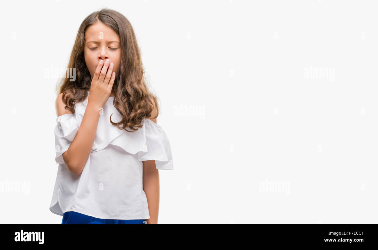Brunette hispanic girl bored yawning tired covering mouth with hand. Restless and sleepiness. Stock Photo