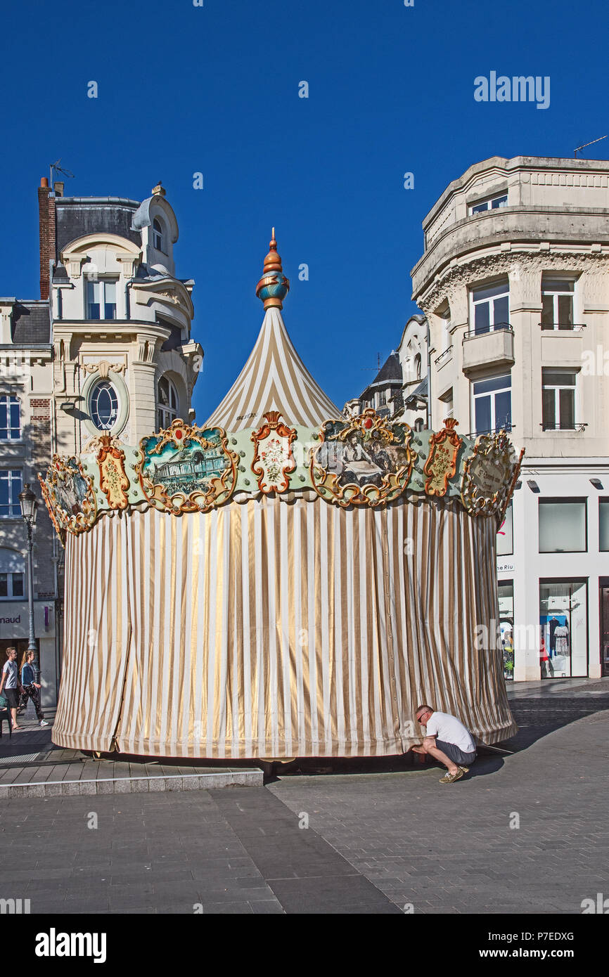 Charming old fashioned traditional carousel children’s roundabout being closed up for the night in Place de l’Hotel de Ville St Quentin Aisne France Stock Photo