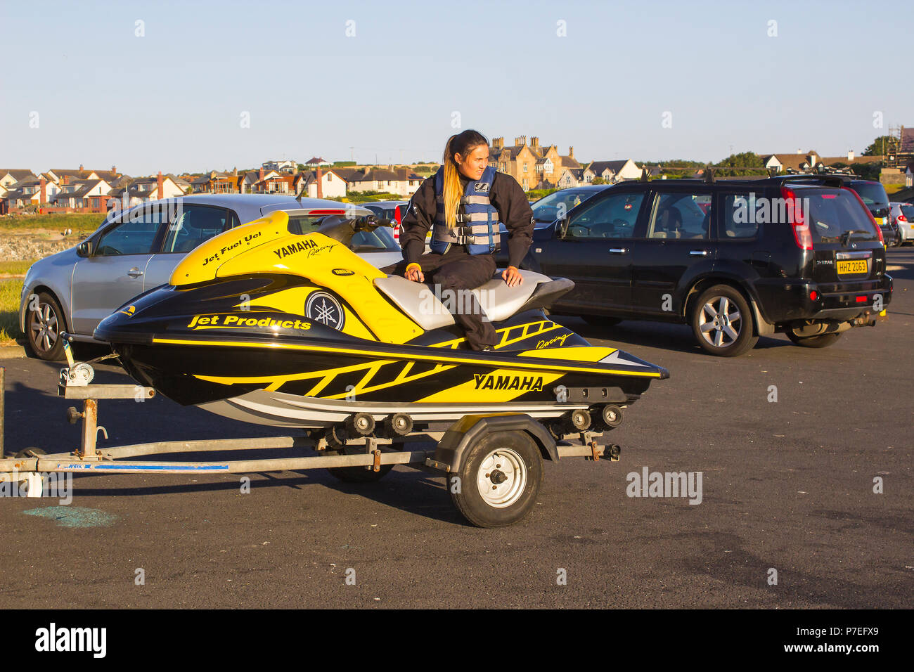 29 June 2018 A young woman in wet gear sits on a powerful Yamaha Jet-Ski at Groomsport Harbour Northern Ireland in preparation for launching Stock Photo