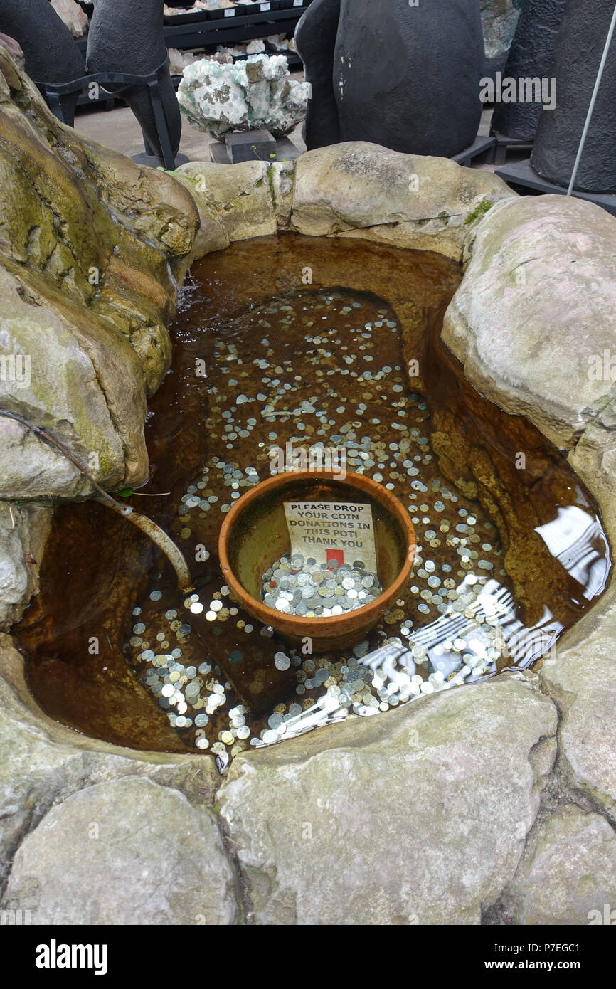Wishing well pond with silver coins underwater Stock Photo