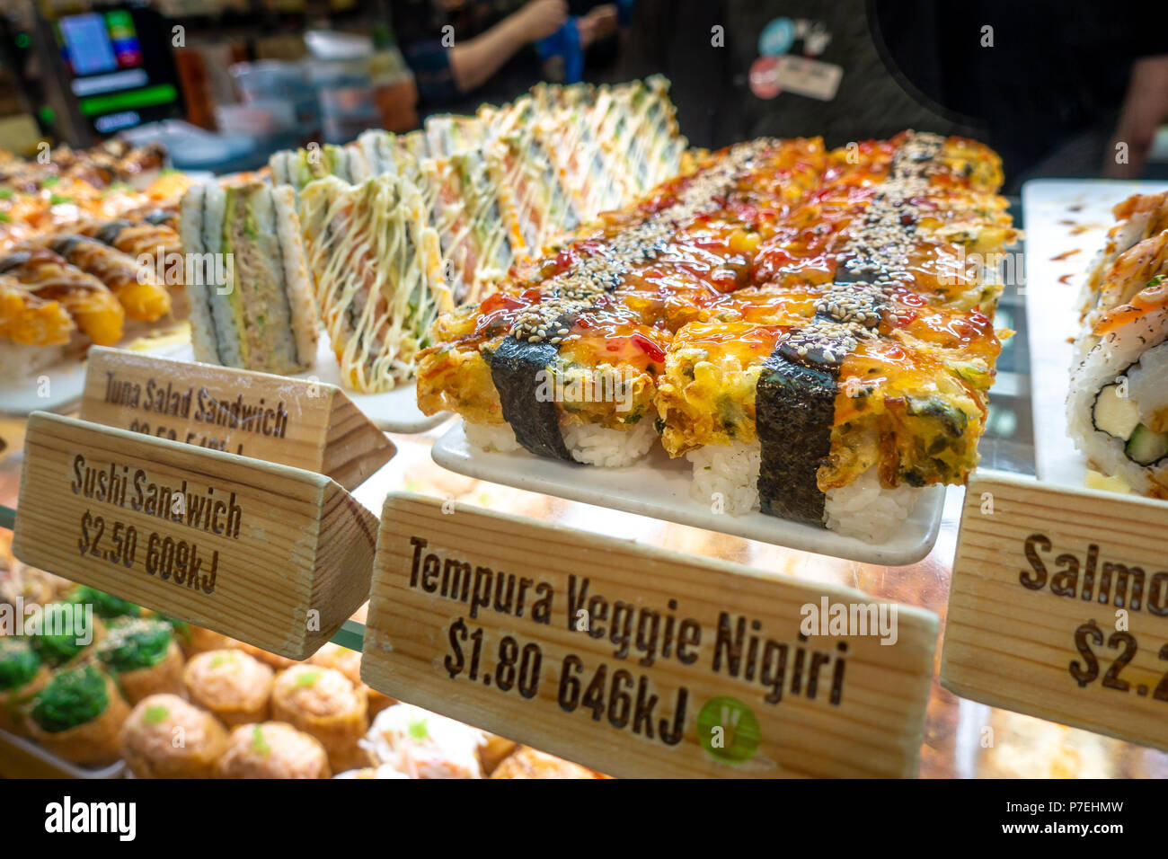 Different kinds of sushi displayed in counter with English name, calories and price listed on each tag. Melbourne, VIC Australia. Stock Photo