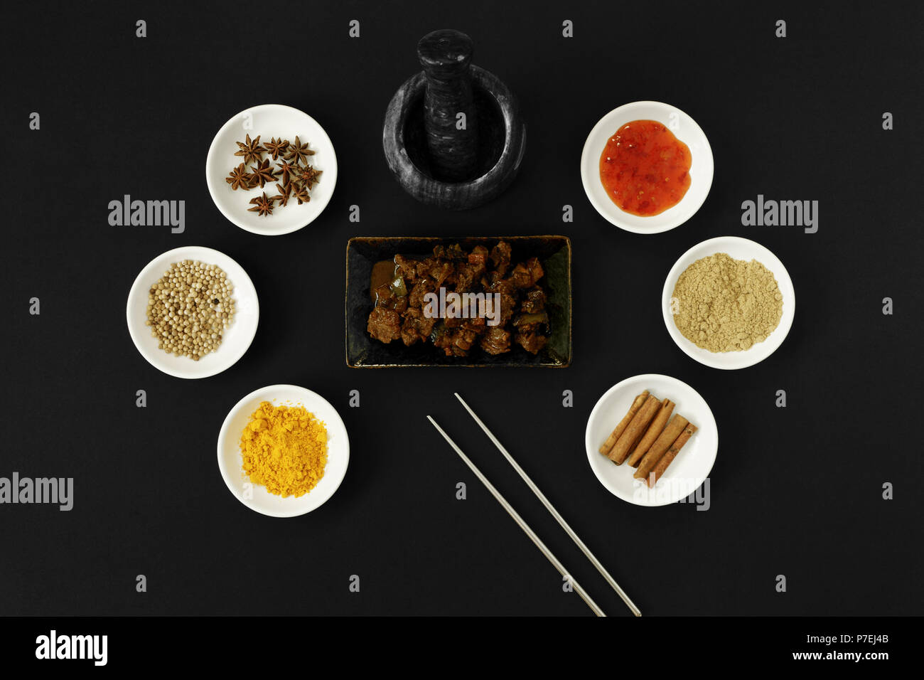 Beef dendeng cuisine with asian spices, herbs and cooking ingredients on black background. Stock Photo