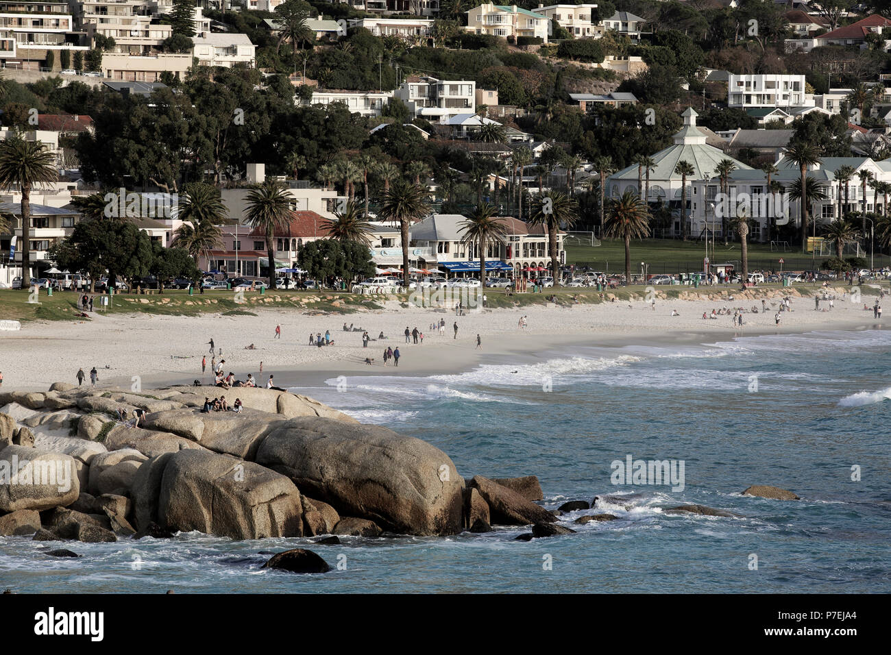 People enjoy a warm winters day at Camps Bay, Cape Town, South Africa Stock Photo