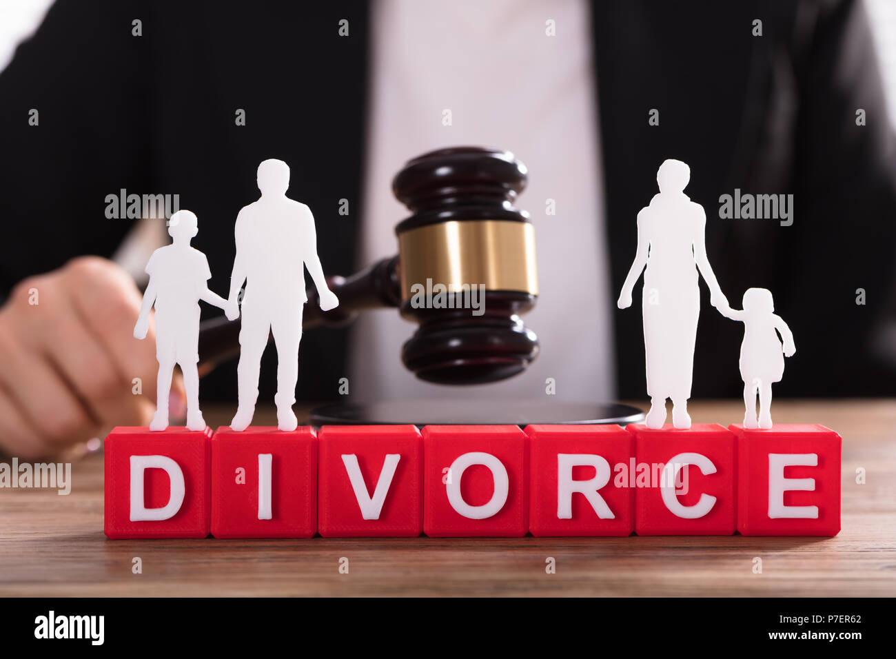 Separated Family Figure Cut Out Standing On Divorce Blocks In Front Of Judge Striking Gavel Stock Photo