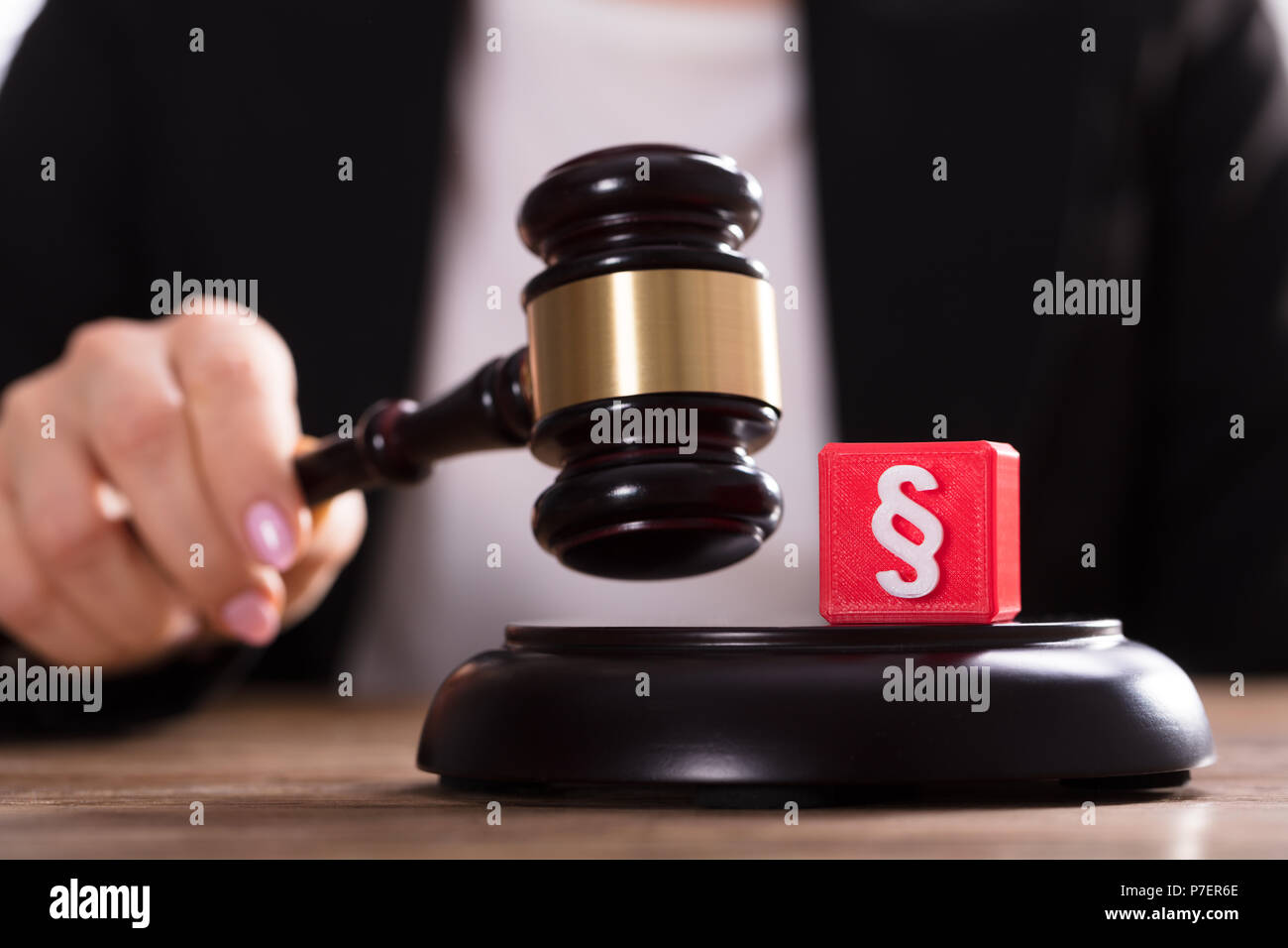 Close-up Of Cubic Block With Paragraph Symbol Near Judge Striking Mallet Stock Photo