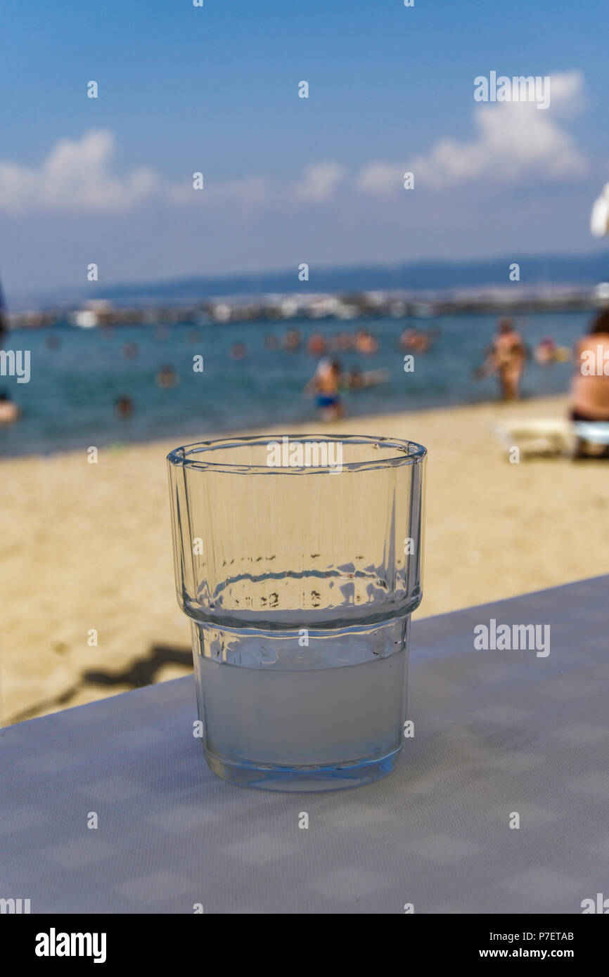 Greek tavern alcoholic drink. Ouzo on the rocks served on a glass in