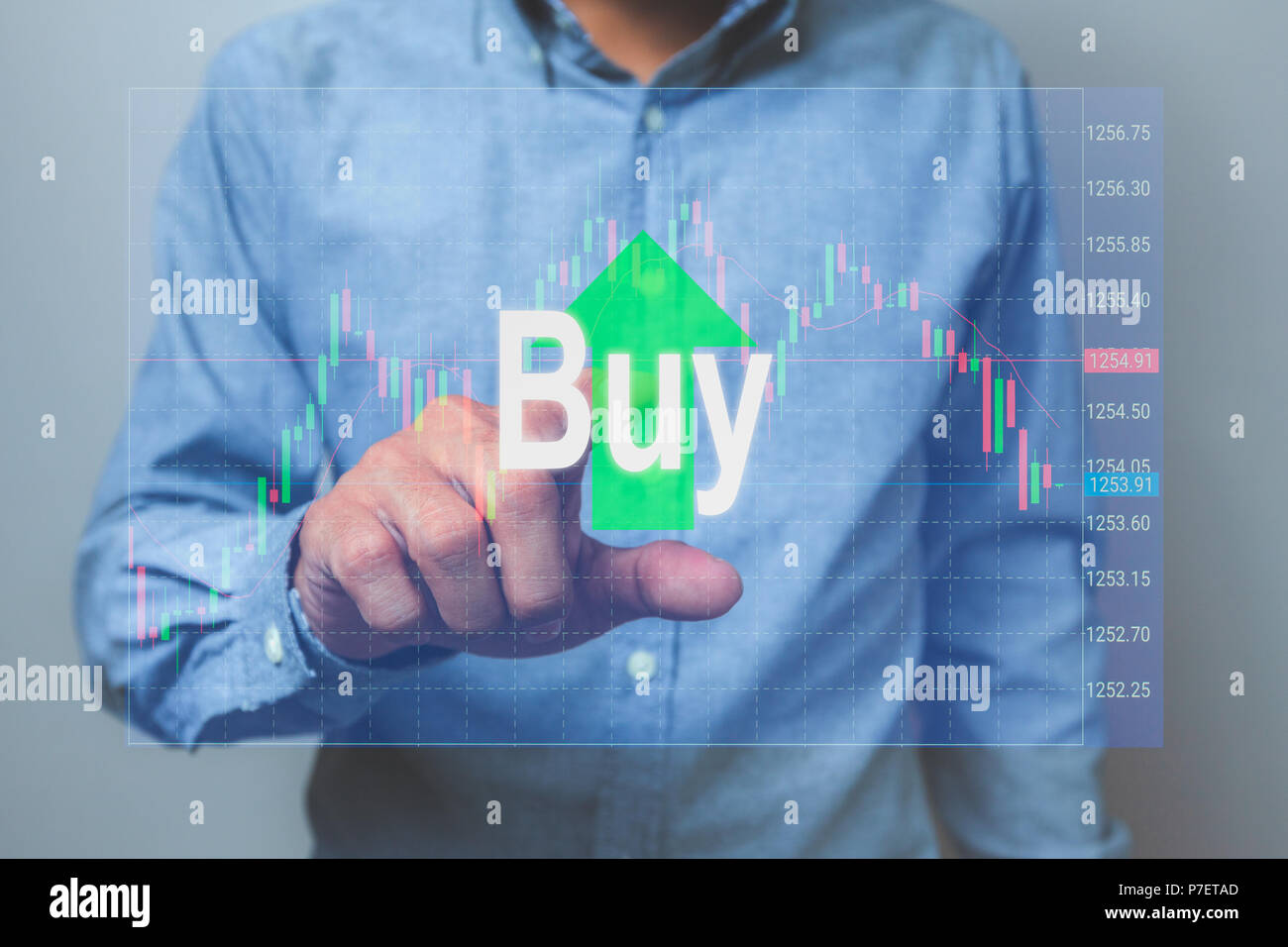 Businessman view on the hologram screen, he will press the buy button stock market. Stock Photo