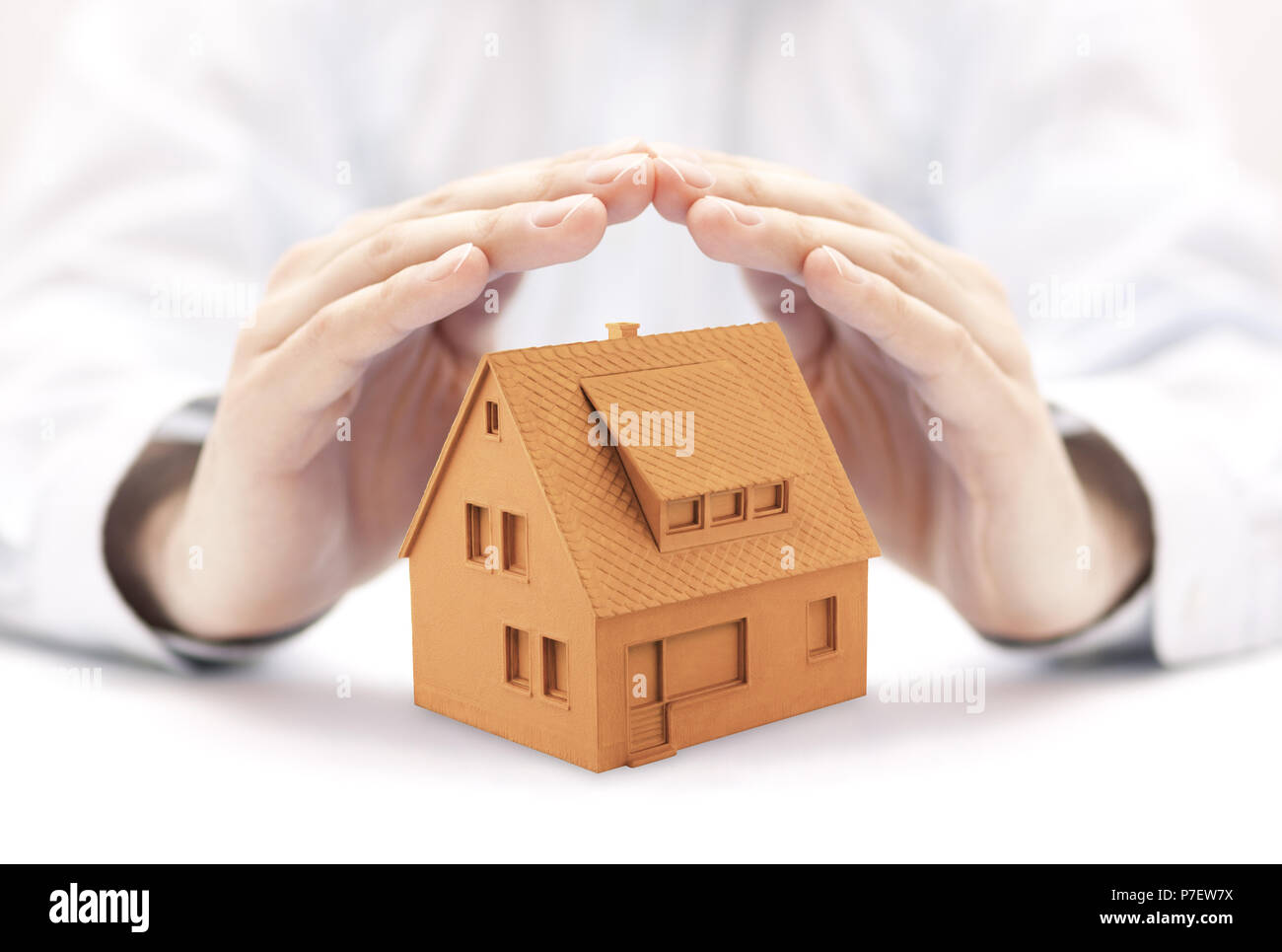 Small orange house in hands Stock Photo
