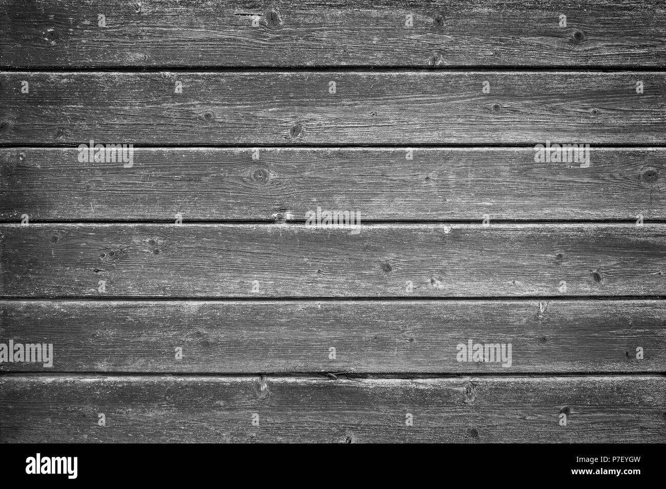 Full frame background of an old and faded wood board wall in black and white with vignette Stock Photo