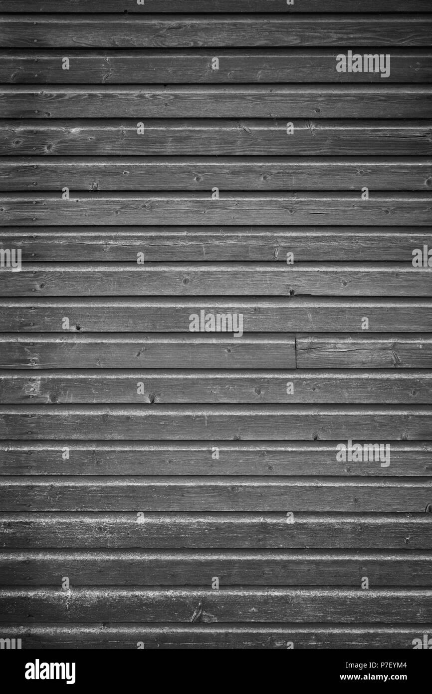 Full frame background of an old and faded wood board wall in black and white with vignette Stock Photo