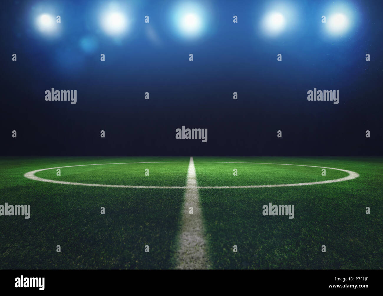 Midfield of grass soccer field at night with headlights Stock Photo