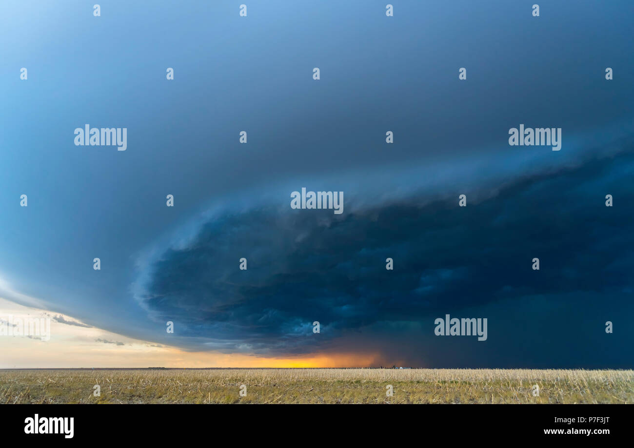 Large, powerful tornadic supercell storm moving over a field in 
