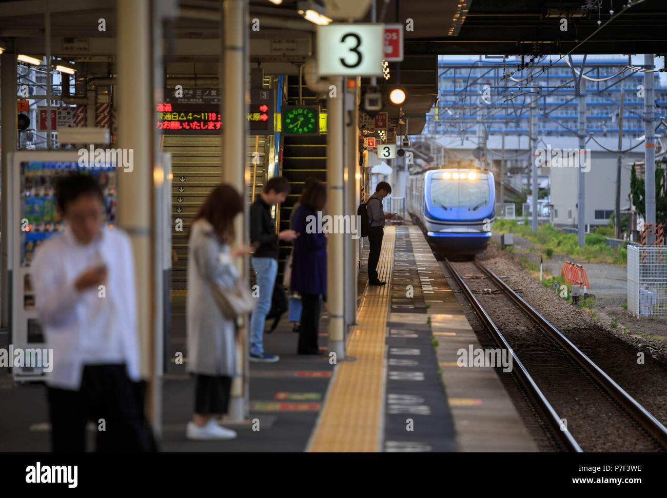 Kakogawa, Japan: May 2, 2018: Passengers on phones wait for train at JR Higashi-Kakogawa Station in Hyogo Stock Photo