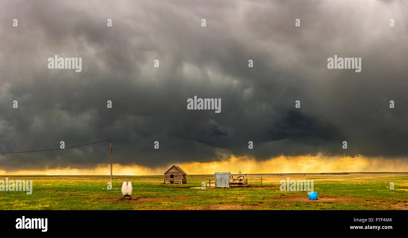 A mezocyclone storm with dark, gray clouds forming over the plains in Tornado Alley, Oklahoma at sunset Stock Photo