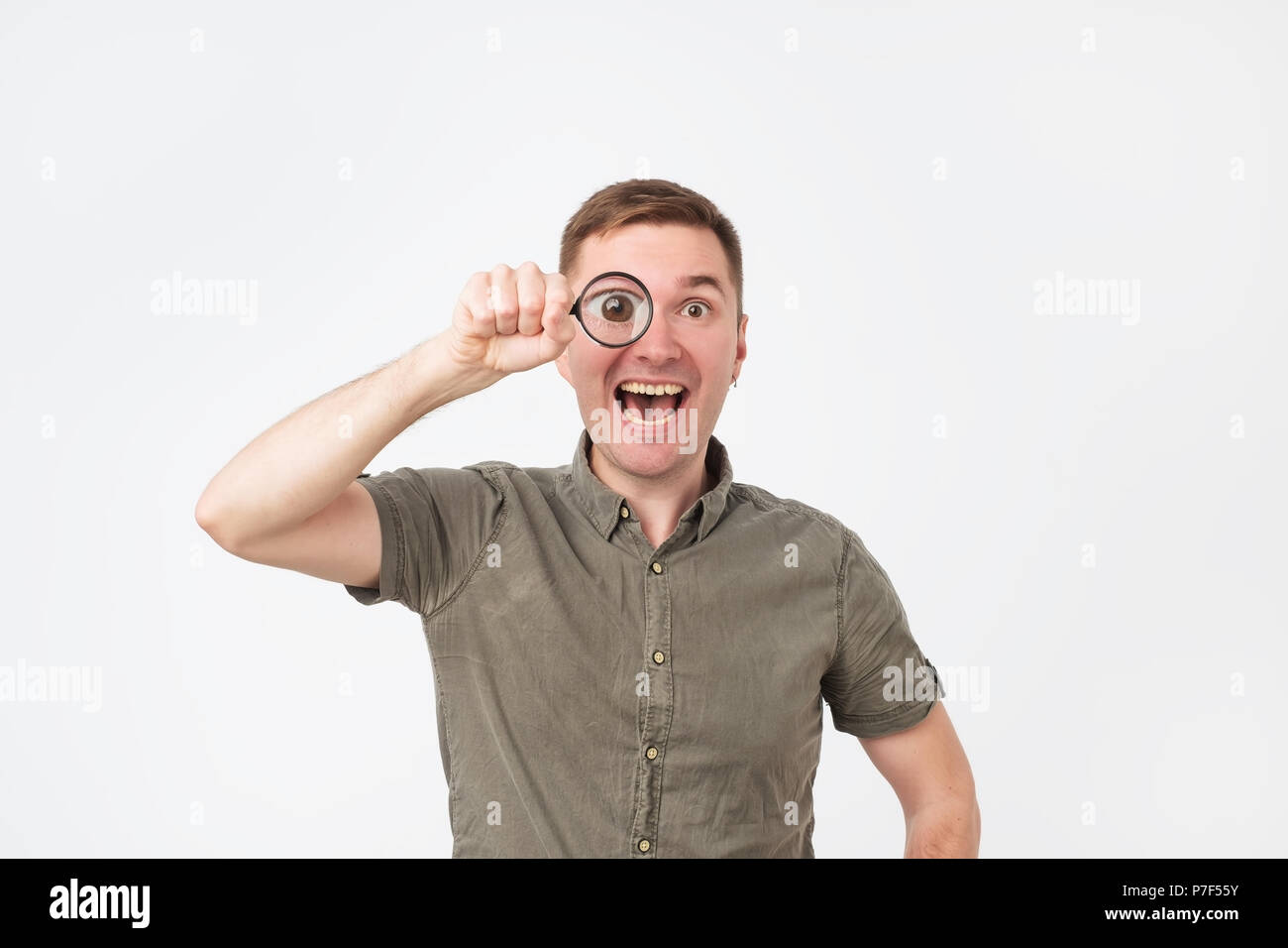 Funny european middle aged man holding magnifying glass portrait Stock Photo