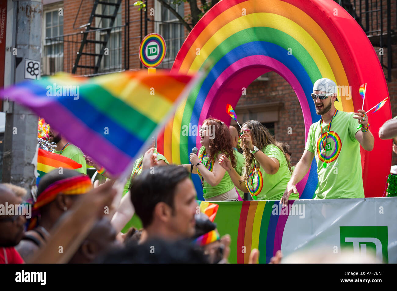 NEW YORK CITY - JUNE 25, 2017: Participants wave flags on a TD Bank float with a rainbow arc in the annual Pride Parade in Greenwich Village Stock Photo