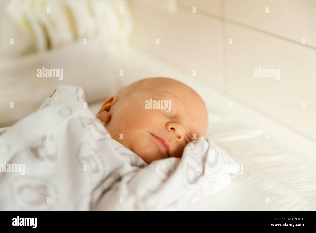 Cute newborn baby boy sleeps in a nursery while changing diapers Stock