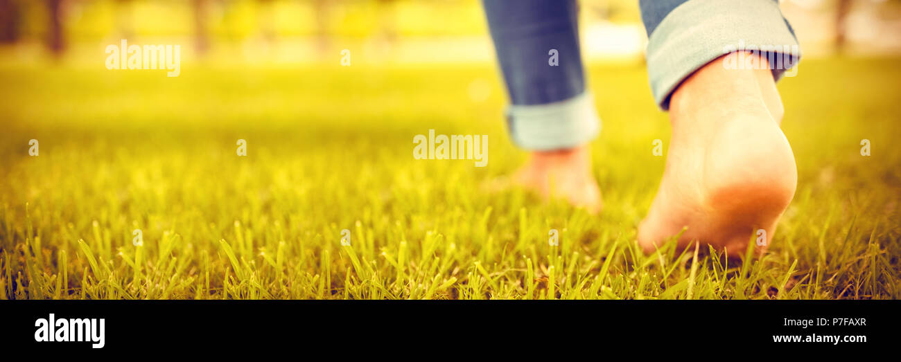 Low section of woman walking on grass Stock Photo